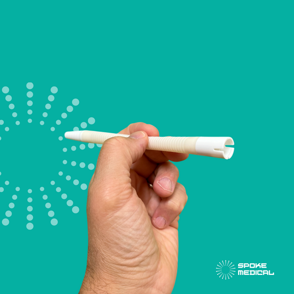 The adapter tube held in the hand, angled to show the slotted connector that fits a suction unit